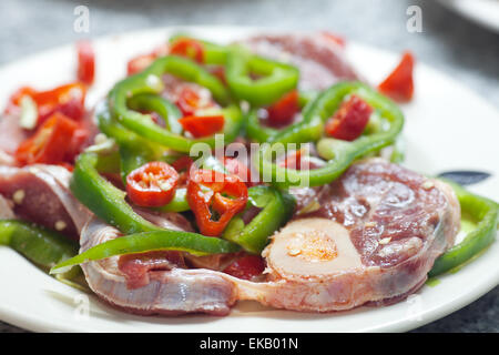 Bistecca con peperoni rossi e verdi su una piastra Foto Stock