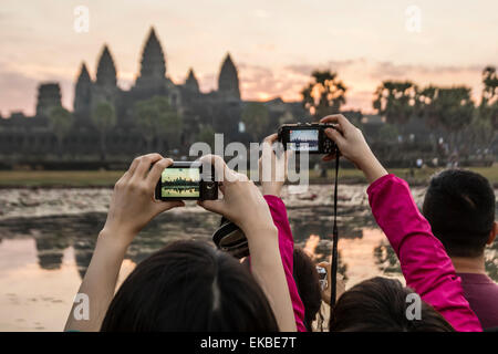 I turisti fotografare il tramonto sull'entrata ovest di Angkor Wat, Angkor, UNESCO, Siem Reap, Cambogia, Indocina, Asia Foto Stock