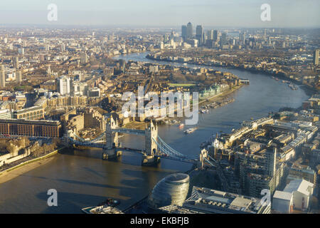 Vista in elevazione del Fiume Tamigi guardando ad Est verso Canary Wharf con il Tower Bridge in primo piano, London, England, Regno Unito Foto Stock