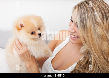 Giovane donna che gioca con il suo cane scadenti Foto Stock