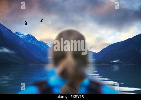 Vista posteriore di un escursionista femmina guardando a Gabbiani e lago di montagna, Haines, Alaska, STATI UNITI D'AMERICA Foto Stock