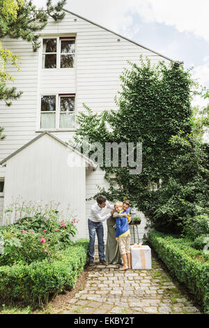 Coppia matura saluto nipote in giardino Foto Stock