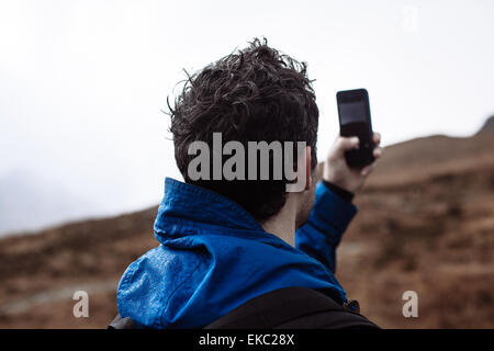 Metà uomo adulto prendendo foto con il telefono Foto Stock