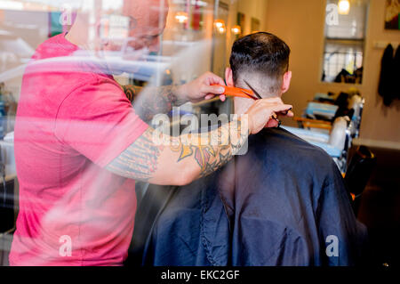 Giovane uomo avente il suo taglio di capelli Foto Stock