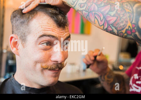 Giovane uomo avente il suo taglio di capelli Foto Stock