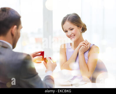 Eccitato giovane donna guardando il fidanzato con anello Foto Stock