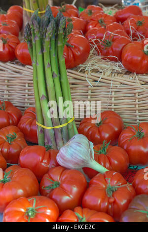 Un display di asparagi freschi, pomodori, aglio e su un mercato in stallo Foto Stock