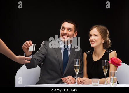 Coppia sorridente pagando per la cena con carta di credito Foto Stock