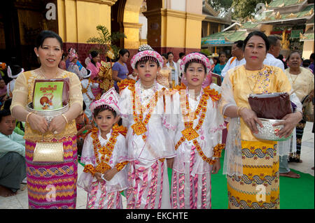 I bambini e le loro famiglie parade di vistosi bejeweled costumi in loro venuta di età cerimonia in Myanmar Mandalay Foto Stock