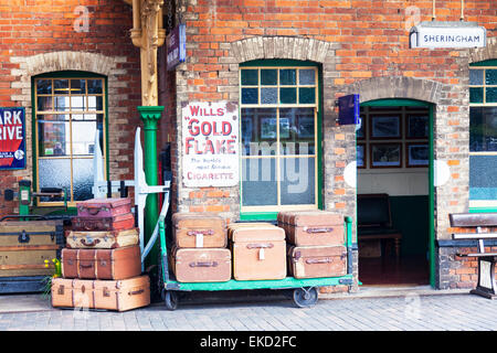 Bagagli sul passato, Sheringham stazione ferroviaria, North Norfolk, Regno Unito casi piattaforma di vecchi tronchi di viaggio Foto Stock