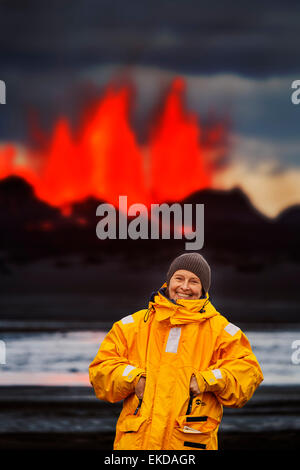 Donna in piedi dalla lava incandescente dall'eruzione in corrispondenza della fessura Holuhraun, vicino al vulcano Bardarbunga, Islanda Foto Stock