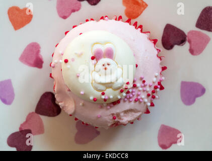 Tesco di fragole e panna Felice Pasqua tortina con il coniglietto di pasqua coniglio su piastra di cuori impostato su sfondo rosa Foto Stock