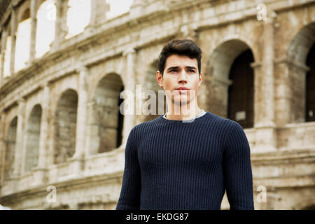 Attraente giovane uomo a Roma in piedi di fronte al Colosseo Foto Stock