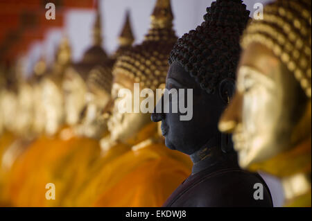 Una fila di statue di Buddha con uno in attesa di essere ristrutturato. Wat Pho, Bangkok, Thailandia Foto Stock
