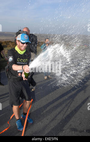 Kevin Carr completa il suo record correre intorno al mondo, festeggia con lo Champagne dopo il ritorno di Haytor Dartmoor Devon Regno Unito Foto Stock