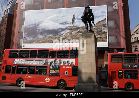 Un gigante di annuncio tramite Affissioni per l'uso di iphone visto sul lato di una centrale di Londra edificio, giustapposti con bus e pubblicità a WW1 memorial Soldier of the Royal Fusiliers. Foto Stock