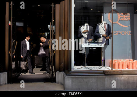 Una guardia di sicurezza ispeziona una borsa del cliente all'ingresso del menswear rivenditore Austin Reed nel centro di Londra. Foto Stock