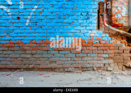 Il vecchio muro di mattoni metà dipinto in colore azzurro e rusty tubo di acqua, un sacco di copyspace Foto Stock