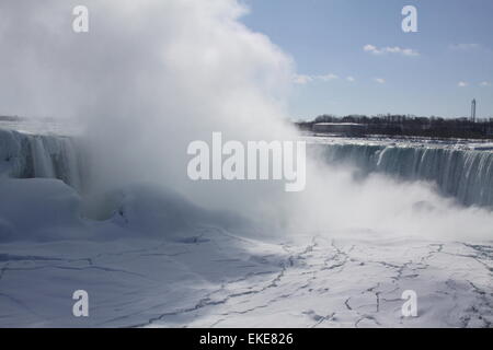 Falls a Niagara Falls, di nebbia che si innalzano quasi coprendo il cade dalla vista, durante i mesi invernali. Il ghiaccio formato al di sopra al di sotto e besid Foto Stock