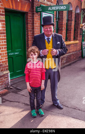 Cinque anni di vecchio ragazzo con il grasso controllore Stazione Ropley, linea di crescione, metà Hants Railway, Hampshire, Inghilterra. Foto Stock