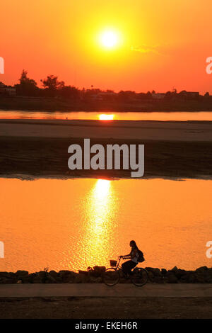 Stagliano donna a cavallo del fiume Mekong waterfront al tramonto, Vientiane, Laos, sud-est asiatico Foto Stock