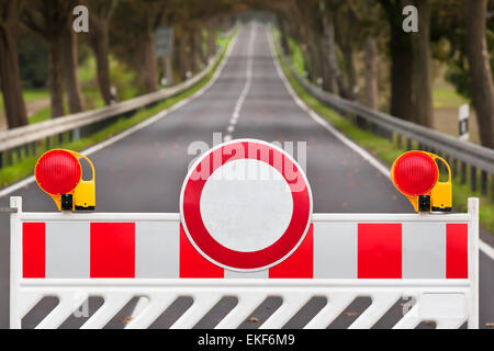 Rosso e bianco strada colorata barriera a lunga strada vuota Foto Stock