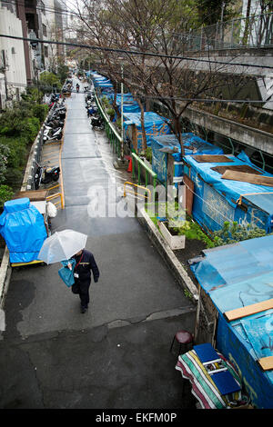 Un uomo cammina accanto ai campi di senzatetto in Miyashita Park il 10 aprile 2015, Tokyo, Giappone. Shibuya è volto a migliorare l'immagine di Miyashita Park nel 2016. L'ultimo programma di ristrutturazione, supportati da Nike Giappone sotto una denominazione accordo diritti, si è conclusa nel 2011. Prima che i lavori di ristrutturazione inizia il piano è quello di spostare tutti i senzatetto che attualmente vivono nel parco in una posizione diversa. Shibuya è una delle molte aree di Tokyo che mira a rafforzare la sua immagine prima del 2020 Tokyo Olimpiadi. © Rodrigo Reyes Marin/AFLO/Alamy Live News Foto Stock