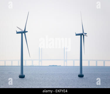 Ponte di Øresund, al di là di 2 turbine di Middelgrunden offshore wind farm (2000), a largo della costa da Copenhagen, Danimarca. Foto Stock