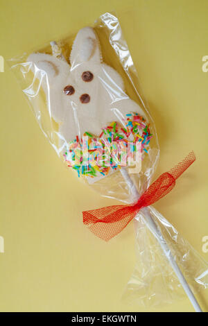 Coniglietto di pasqua marshmallow lollipop sul pallido sfondo giallo Foto Stock