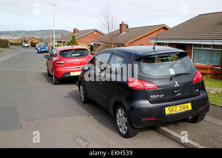 Auto parcheggiata su strada per metà sul marciapiede all'esterno delle abitazioni ad uso residenziale suburban street Foto Stock