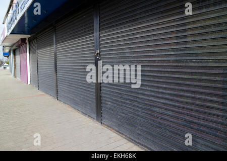 Metallo serramenti di sicurezza su negozi chiusi su un high street nel Regno Unito Foto Stock