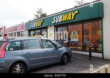 Auto parcheggiate fuori un occupato alla metropolitana e kfc ristorante nel Regno Unito Foto Stock