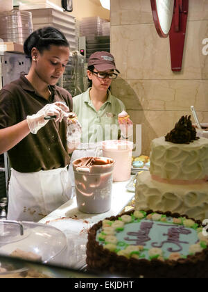 Lavoratori tortini di glassa, Magnolia panificio, Grand Central Terminal, NYC, STATI UNITI D'AMERICA Foto Stock