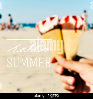 Il testo ciao estate su una immagine sfocata di alcuni gelati in mano a un giovane uomo sulla spiaggia Foto Stock