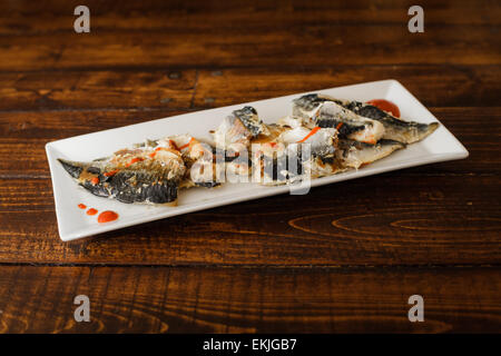 Piastra con i filetti di Sgombro e salsa piccante su un tavolo di legno Foto Stock