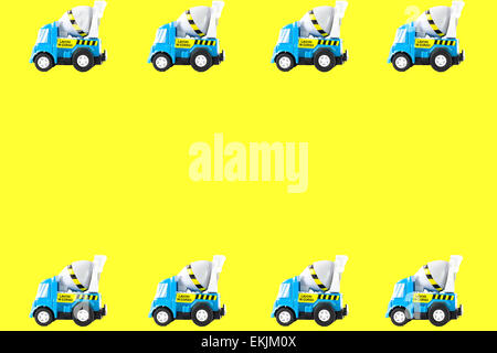 Telaio di automobili giocattolo. Betoniera giocattoli carrello. sfondo giallo Foto Stock