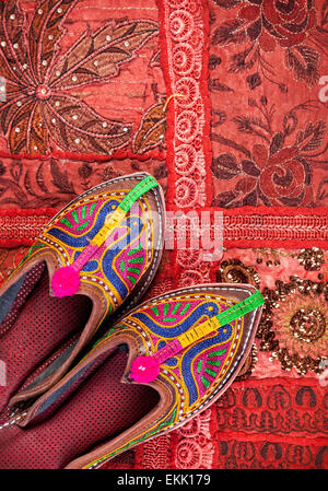 Colorate scarpe etniche su red Rajasthan fodera per cuscino sul mercato delle pulci in India Foto Stock