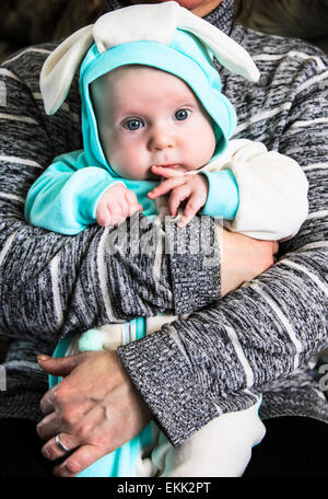 Un bambino vestito come un coniglio nelle mani della madre Foto Stock