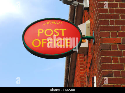 Un ovale rosso Post Office segno nel villaggio di Ludham, Norfolk, Inghilterra, Regno Unito. Foto Stock