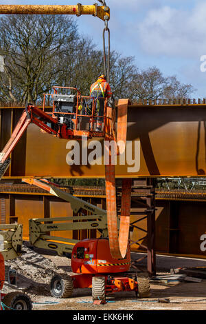 Lancaster, Lancashire, Regno Unito, 11 Aprile, 2015. Gru per il sollevamento si estende per Heysham a M6 Link Road ponte sopra il fiume Lune. I driver utilizzando la M6 attraverso il nord Lancashire vengono avvisati che il Lancashire County Council's £124 milioni di Heysham progetto Link ha raggiunto una nuova fase che possono avere un impatto su utenti di autostrade. La nuova strada è un 4.8km strada a doppia carreggiata che collega il Heysham e Morecambe penisola al Junction 34 della M6, completamente ristrutturato giunzione con nuove strade di slittamento apertura in estate 2016. Credito: MarPhotographics/Alamy Live News. Foto Stock