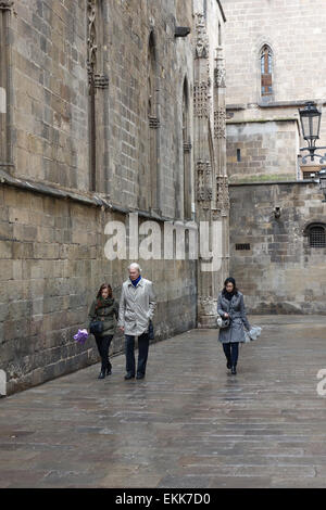 La gente camminare lungo la strada posteriore dietro la cattedrale sulla giornata piovosa a Barcellona Foto Stock