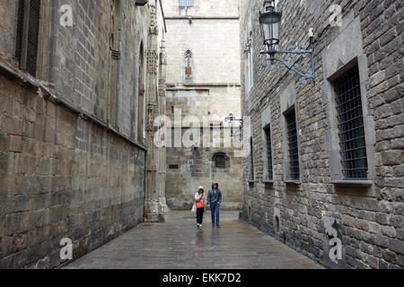 La gente camminare lungo la strada posteriore dietro la cattedrale sulla giornata piovosa a Barcellona Foto Stock