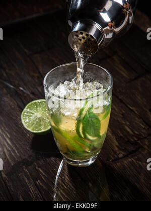 Versando un cocktail in vetro, close-up. Foto Stock