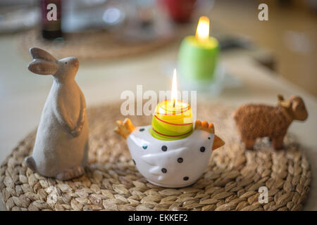 Agnello pasquale bunny figurine di pollo e candele accese Foto Stock