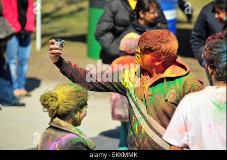 London, Ontario, Canada. 11 aprile 2015. Centinaia di persone si radunano nel Parco Victoria per l annuale Hindu Holi celebrazione a Londra, Ontario. Holi è noto come il festival di colori e vede i partecipanti di gettare polvere colorata in aria per celebrare l avvento della primavera. Credito: Jonny bianco/Alamy Live News Foto Stock