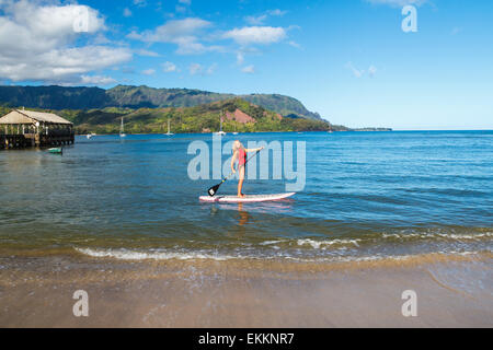 Donna con divertimento sul SUP nella Baia di Hanalei, Kauai Foto Stock