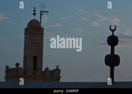 Sunrise silhouette di un minareto vicino alla piazza Jemaa El Fna, Marocco Foto Stock