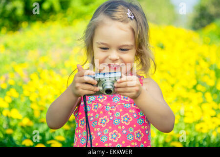 Bambina di scattare le foto su un prato Foto Stock