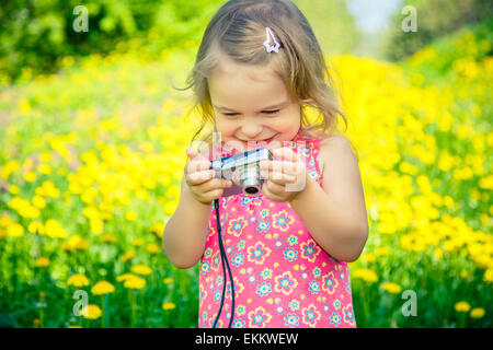 Bambina di scattare le foto su un prato Foto Stock