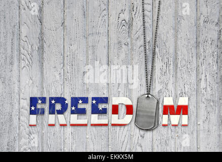 American Freedom in bandiera font con dog tags militari su legno. Foto Stock